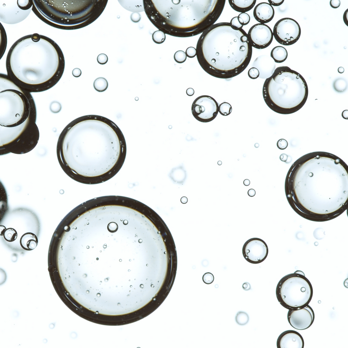 Close-up of clear bubbles suspended in liquid, illustrating a CO₂ bubble serum
