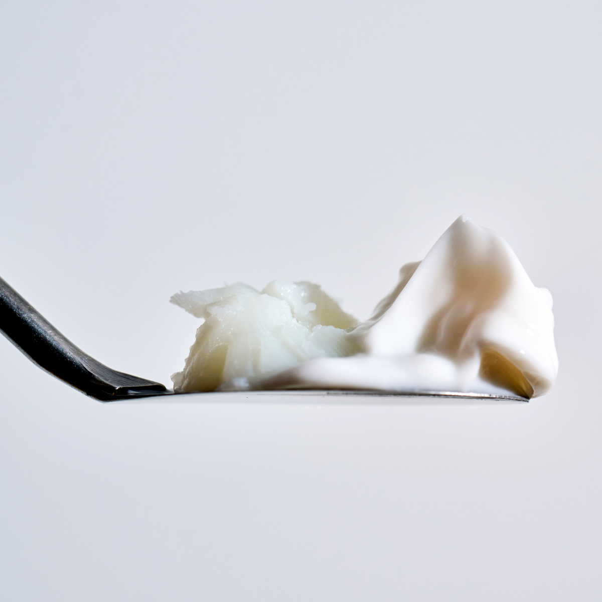 Thick white cream texture on a spoon