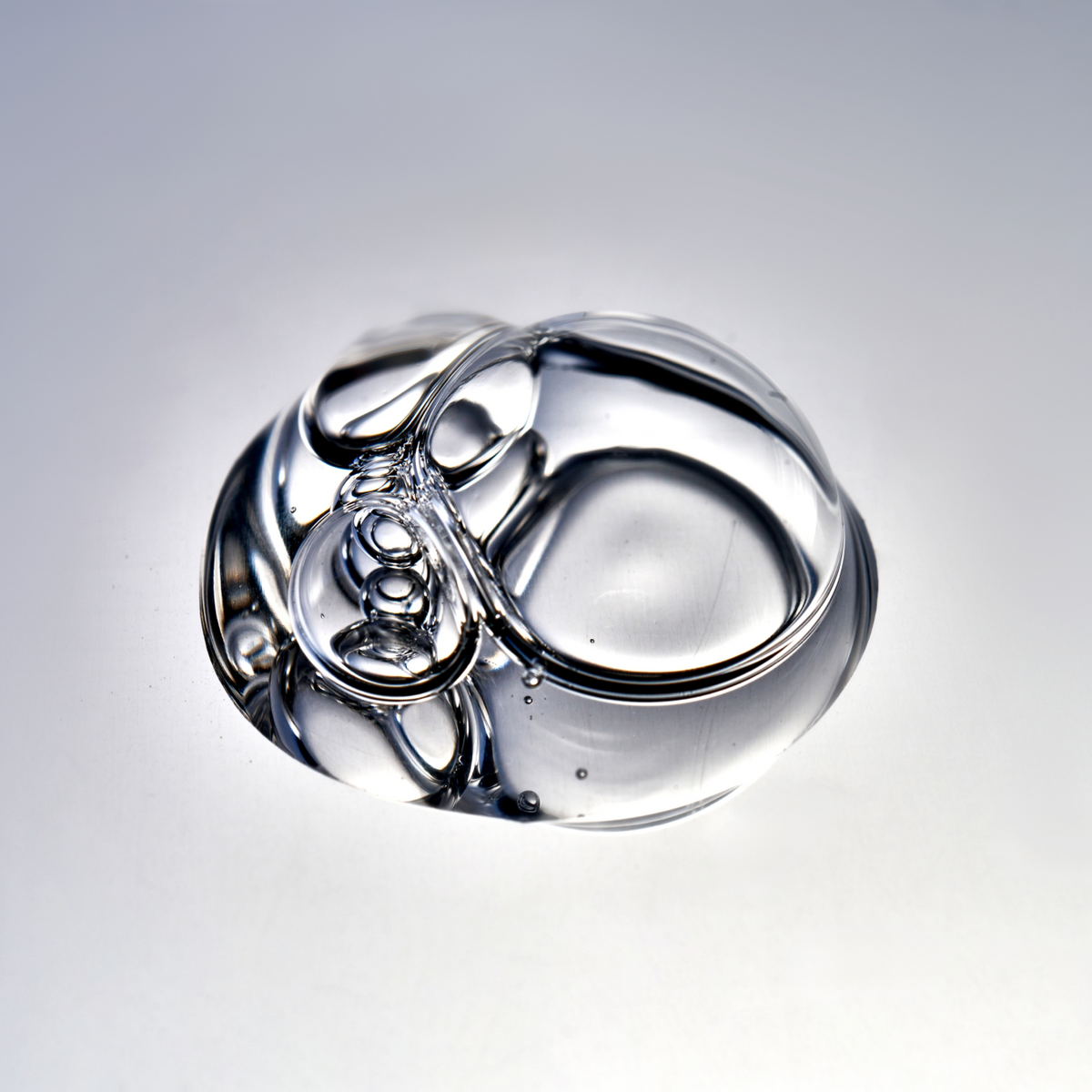 Drop of clear serum with bubbles on a light surface